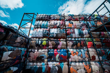 Ιmage of the art installation Return To Sender, which consists of large bales of used clothing